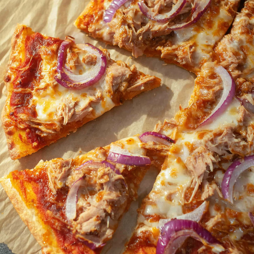 A slice of pizza with tuna and onions.