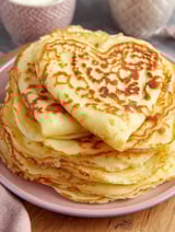 Eine Platte mit Pancakes, die in Form eines Herzens gestapelt sind.