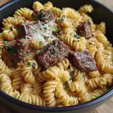 Ein Eintopf mit cremig-würzigem Knoblauchbutter-Steak und Pasta.