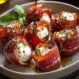 A plate of beef prosciutto wrapped mozzarella bites.